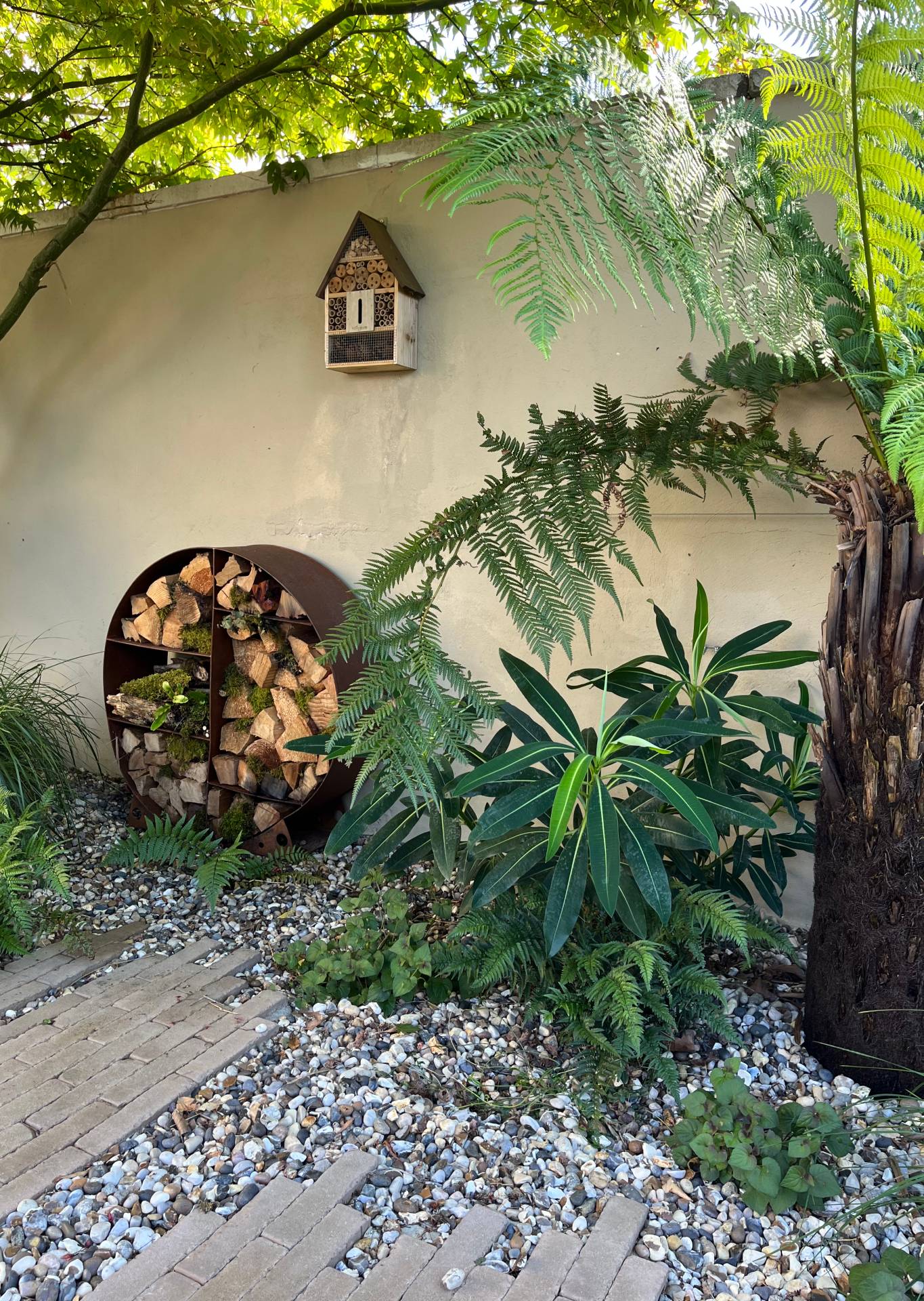 insect hotel and clay paver path through gravel