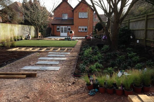 Garden during landscaping with woodland planting, decking and lawn