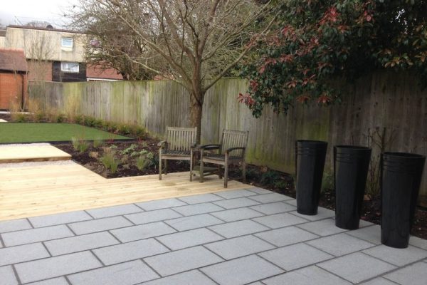 Garden with granite paving, decking ad tall circular planters