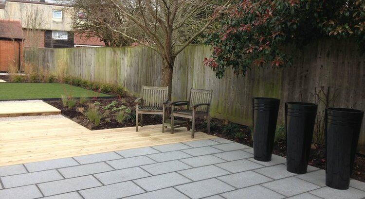 Garden with granite paving, decking ad tall circular planters